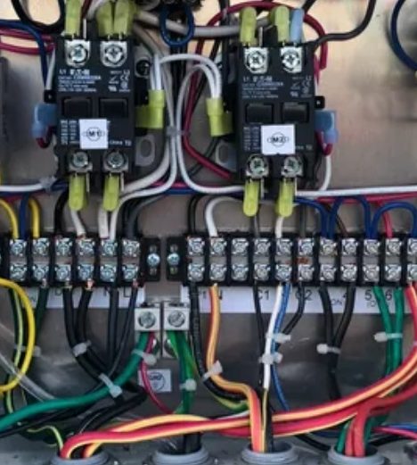 Inside an aerobic septic system control panel with timers and relays
