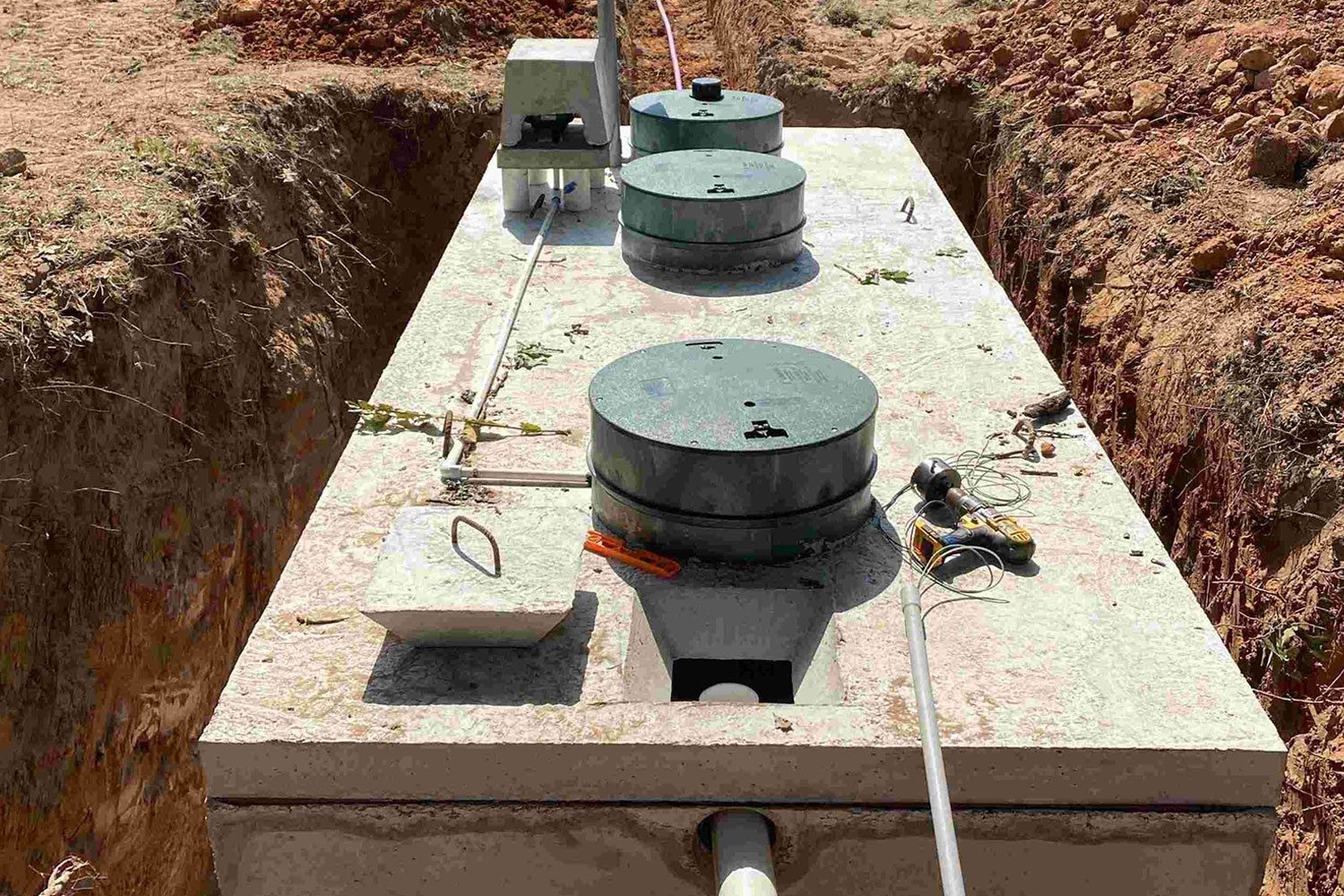 Large concrete septic tank set in a trench for a new system