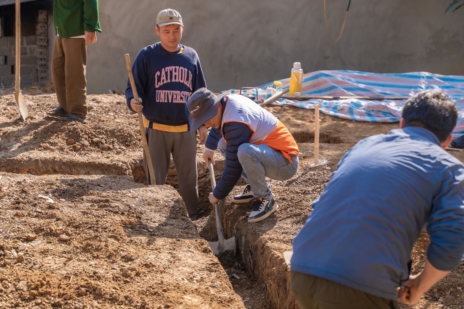 Crew digging a trench by hand to reach a buried line