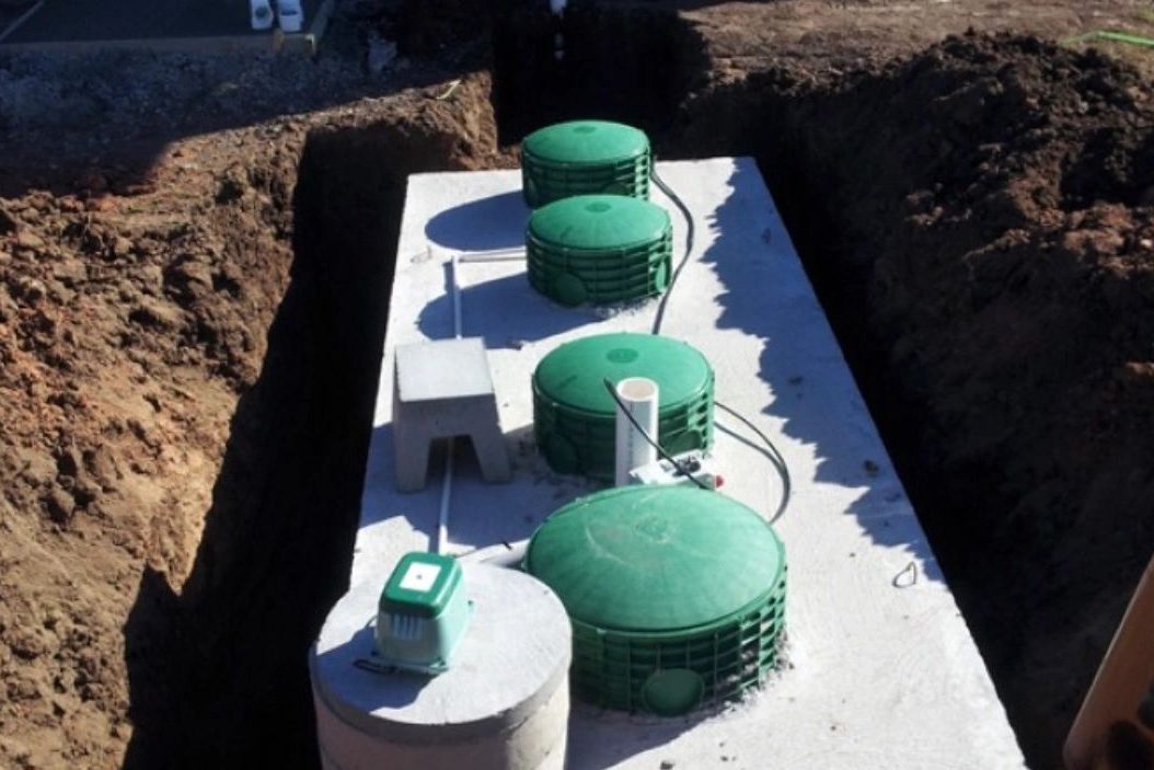 New aerobic septic tank with green access risers installed in an open trench