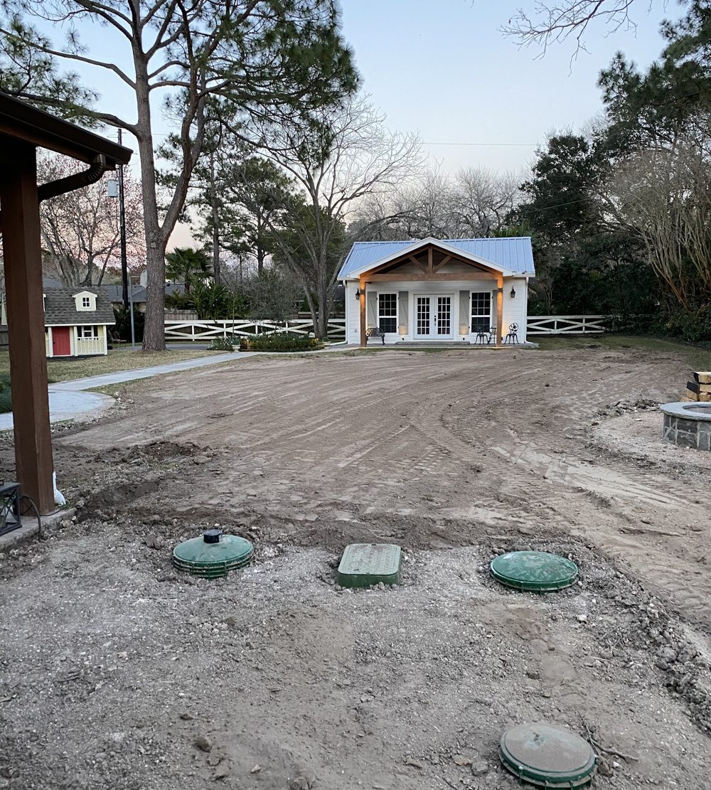 Septic tank lids set flush in the ground in front of a property