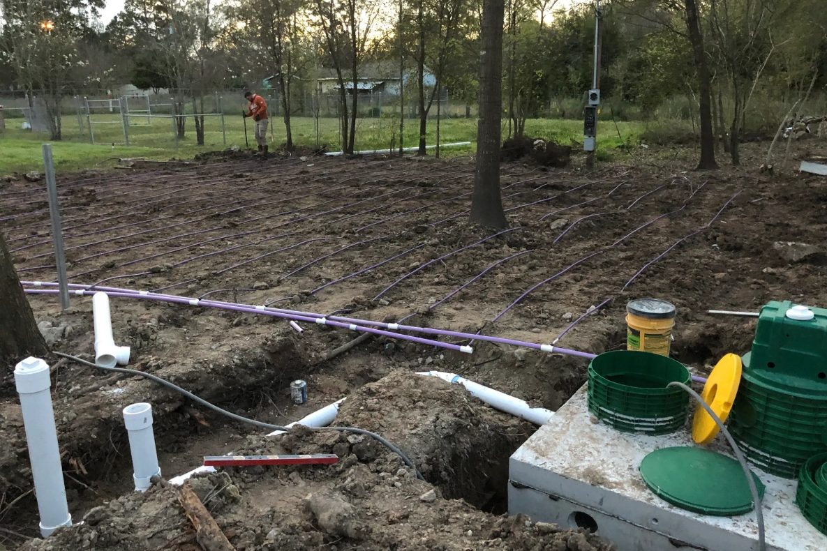 Septic riser and lid repair in progress in a residential yard
